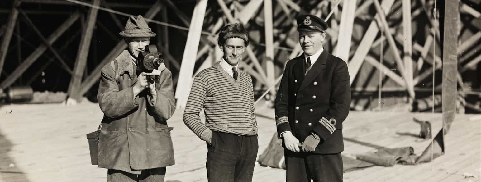 Oskar Omdal sammen med filmfotograf Paul Berge og en uidentifisert person foran luftskiphallen i Ny-Ålesund i 1926