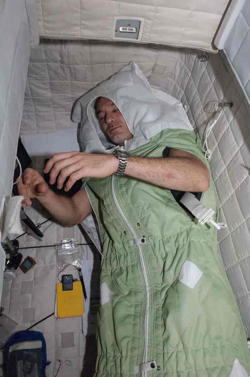 Astronaut i sovepose på Den internasjonale romstasjonen.