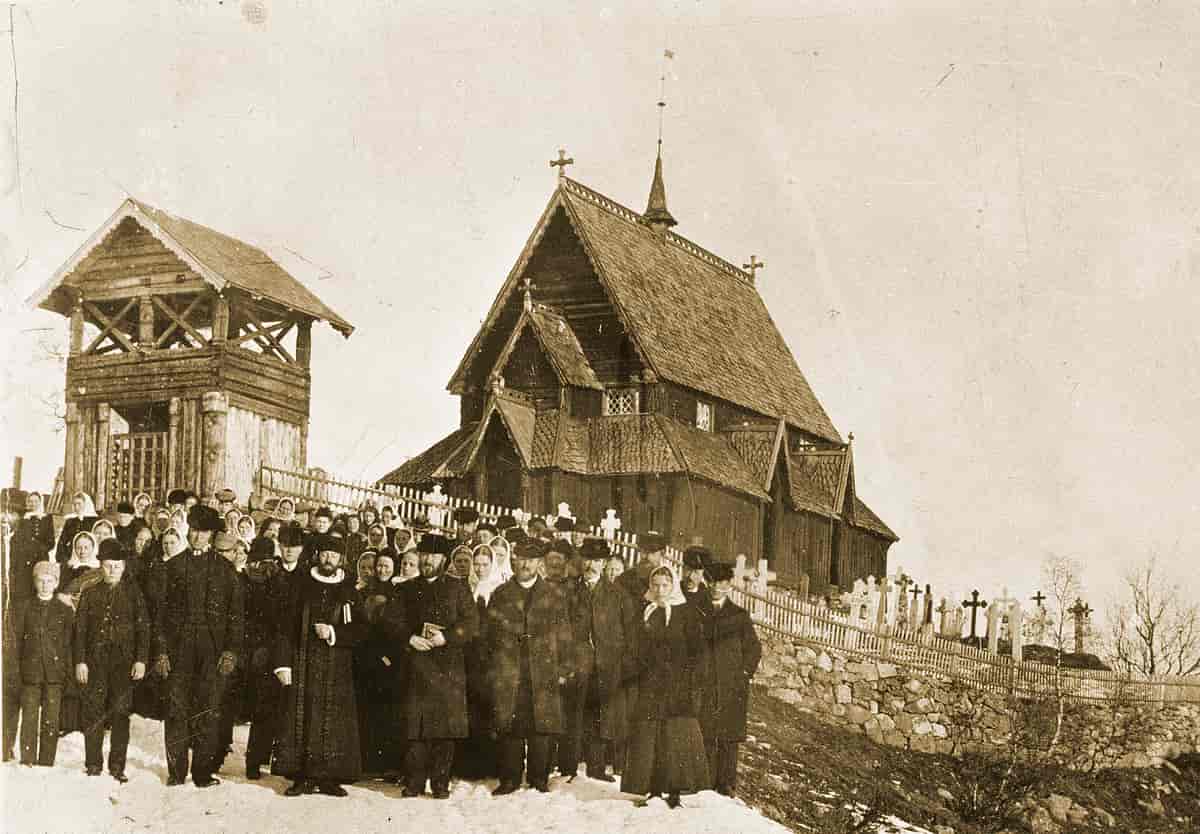 Sokneprest Barth med menighet foran stavkirken omkring 1890.