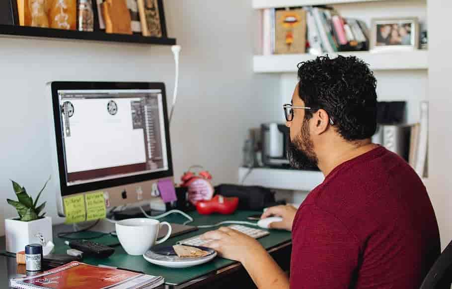 Mann som arbeider med design på computer fra hjemmekontor