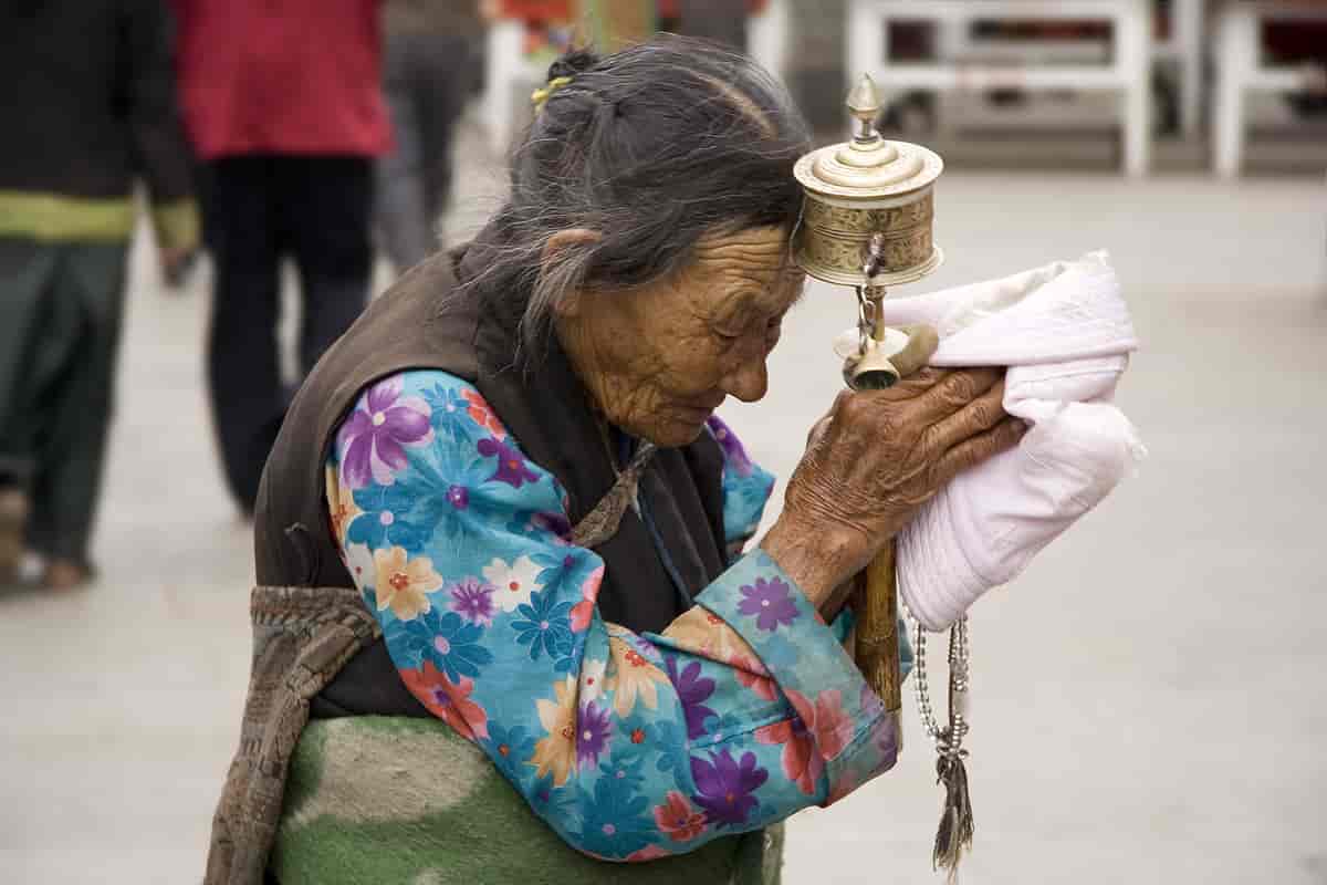 Tibetansk kvinne med bønnhjul