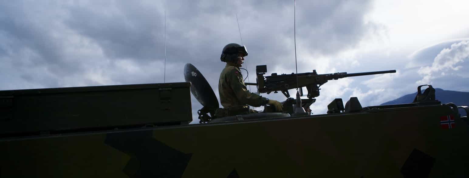 En vognkommandør på en m-113 stormpanservogn bemanner en 12,7mm mitraljøse