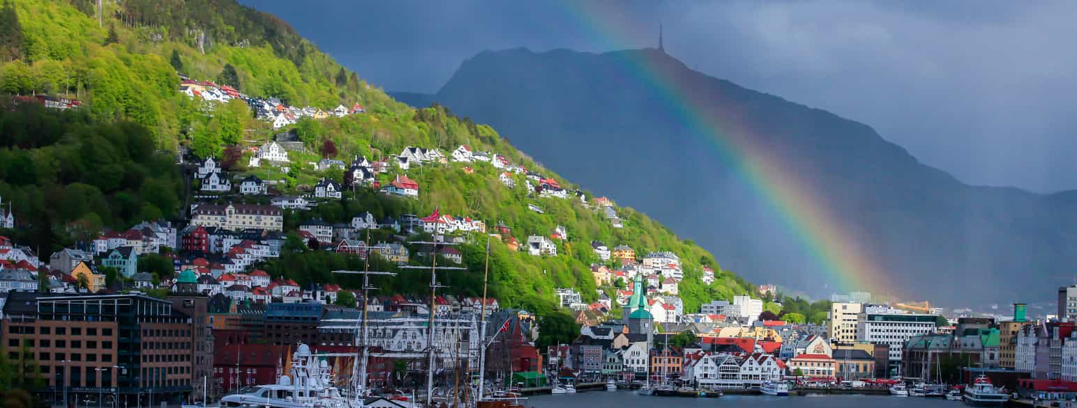Regnbue, solgløtt og mørke skyer over Bergen