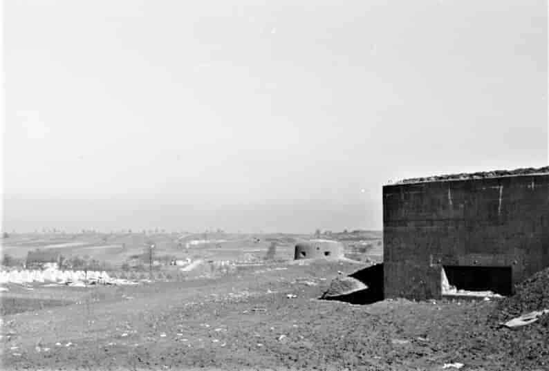Bildet, fra mars 1940, viser et typisk utsnitt av Vestvollen. En større maskingeværbunker i forgrunnen og lenger fremme et Sechsschartenturm, et lavt tårn med seks smutthull for maskingeværild. I bakgrunnen sees stridsvognsperringene.