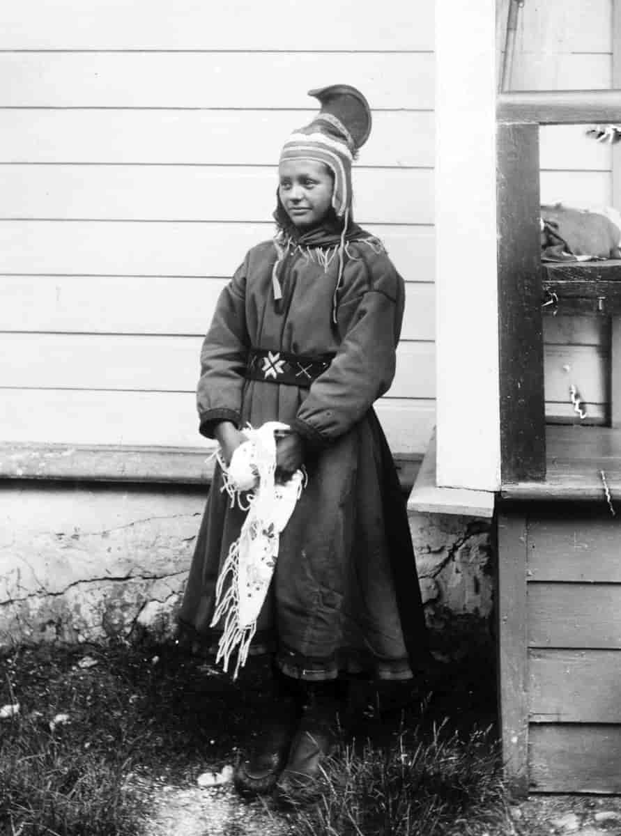 Kvinne fra Sør-Varanger med hornlue og sjal med volangaktig effekt i holbien. Bildet er fra rundt 1900.