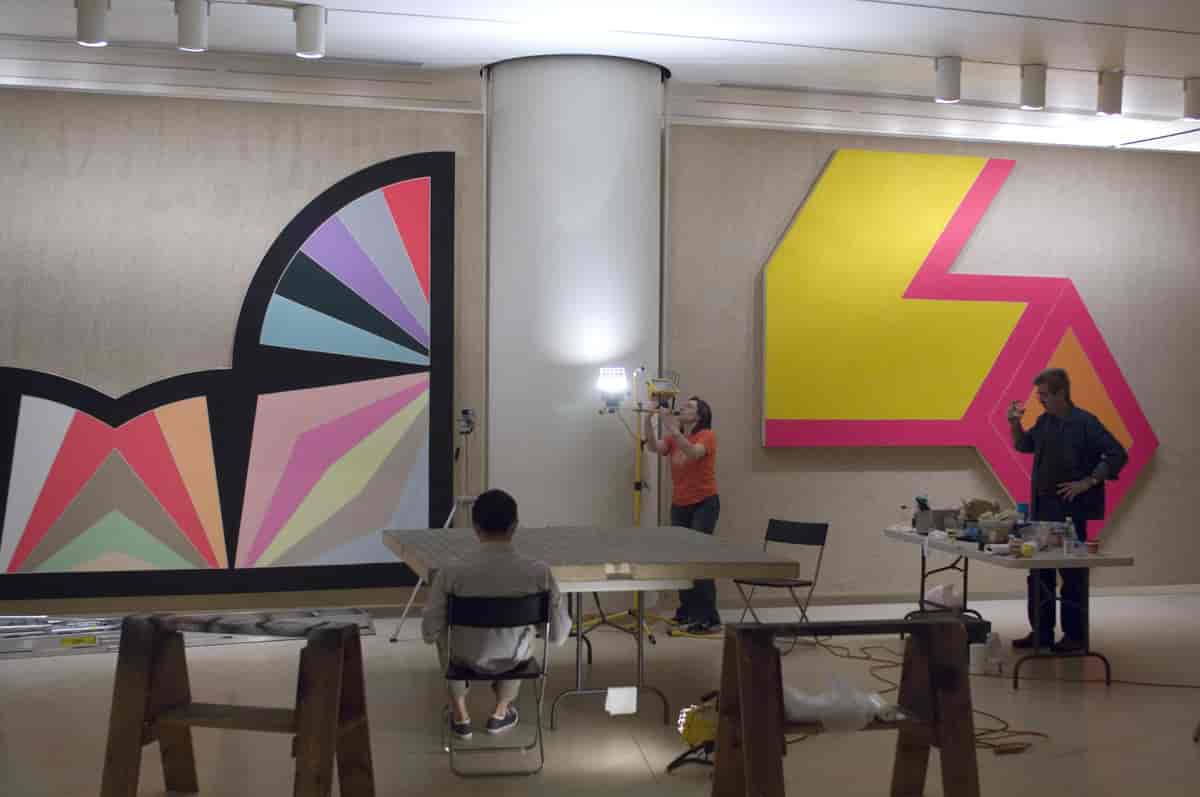 Kunstkonservatorer arbeider med malerier av Frank Stella