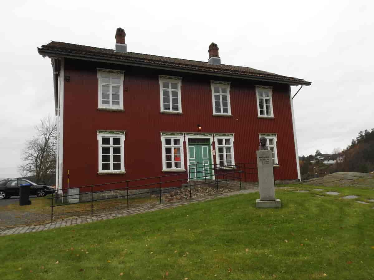 Gjerstad menighetshus med byste av Magnhild Hagelia.
