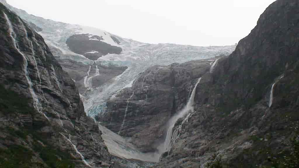 Kanten av Jostedalsbreen der den faller ned i en trang Vestlandsfjord.