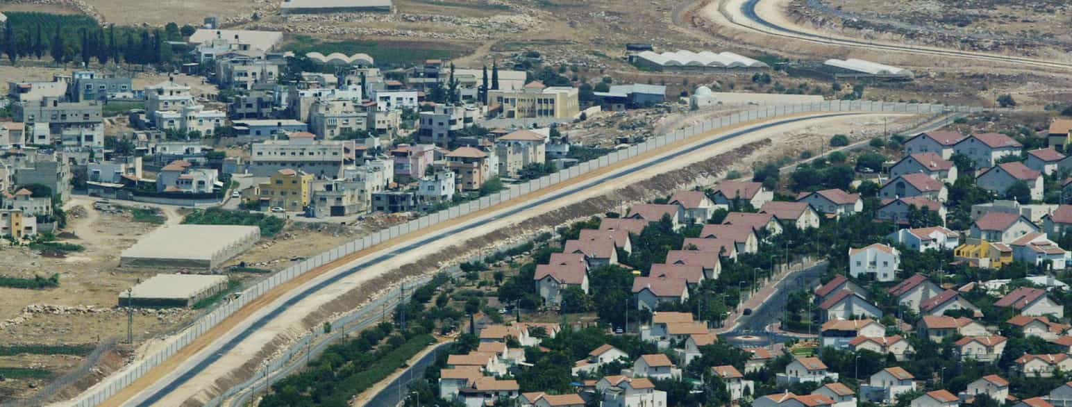Vestbredden: En palestinsk landsby til venstre og en israelsk bosetning til høyre, skilt av en mur. 