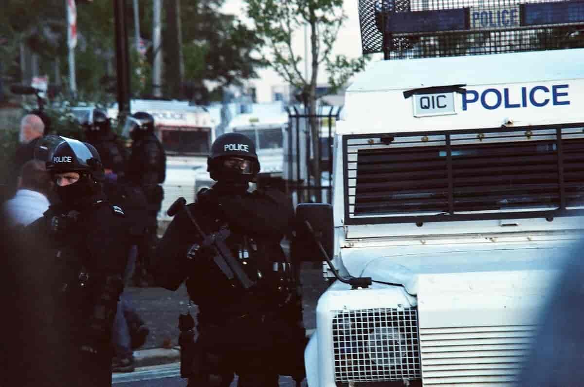 PSNI i opprørsutstyr ved ein pansra politibil i samband med gateuro i Belfast i 2011. 