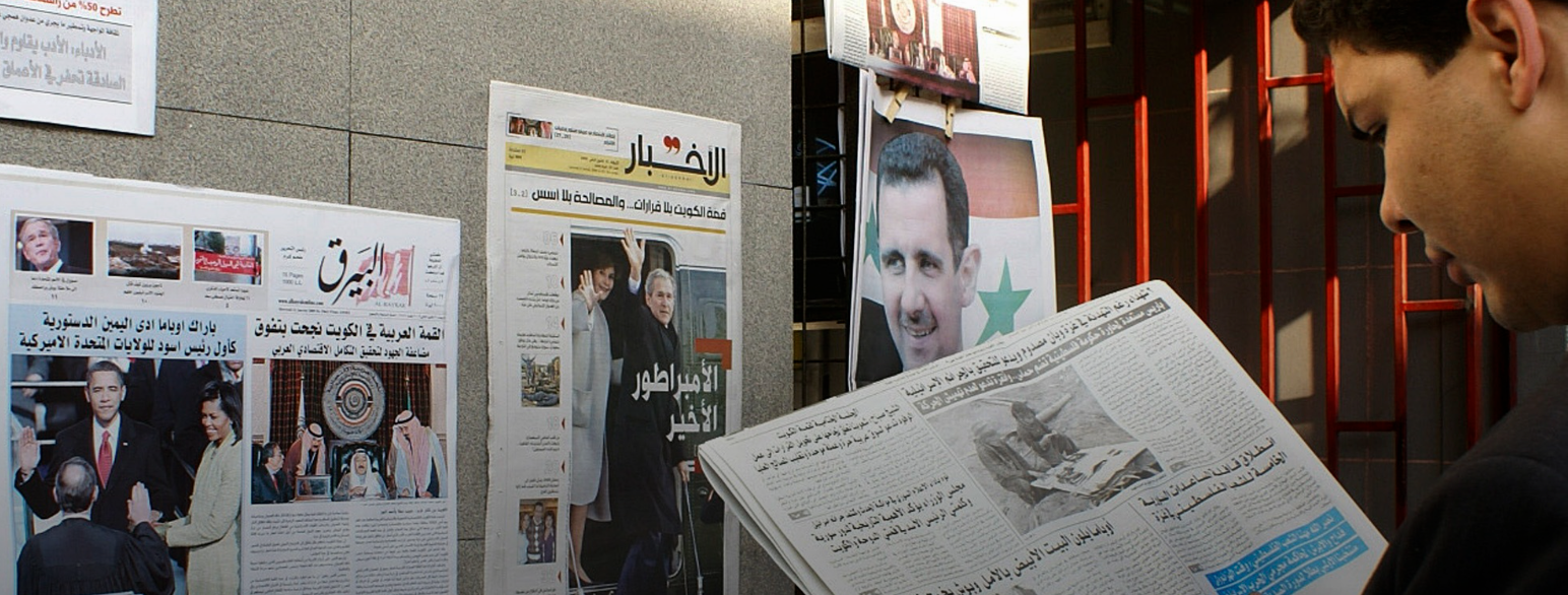 En syrer leser om innsettelsen av USAs president Barack Obama i 2009 ved en aviskiosk i Damaskus