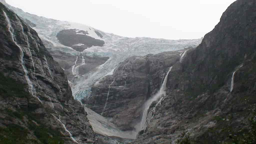Kanten av Jostedalsbreen der den faller ned i en trang Vestlandsfjord.