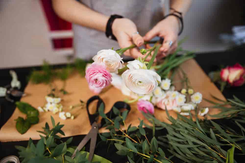 Blomsterhandler som setter sammen en bukett
