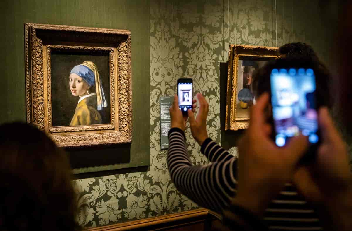 Besøkende med mobiltelefoner i kunstutsilling 