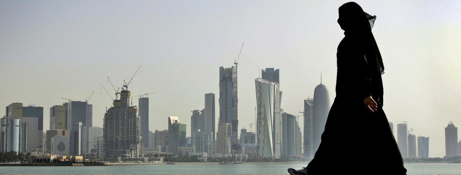 En kvinne går langs promenaden i Qatars hovedstad Doha