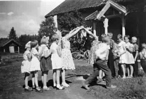 Barn i Ådalsbruk i Løten leker Bro, bro brille. Bildet er tatt en gang mellom 1958 og 1962.
