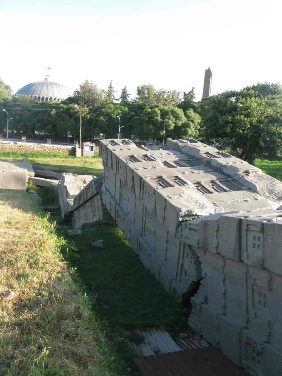 Den største av de kongelige gravstøttene i Aksum var 33 meter og falt antagelig alt da den skulle settes opp. Den moderne Vår frue av Sions katedral i bakgrunnen (1965)