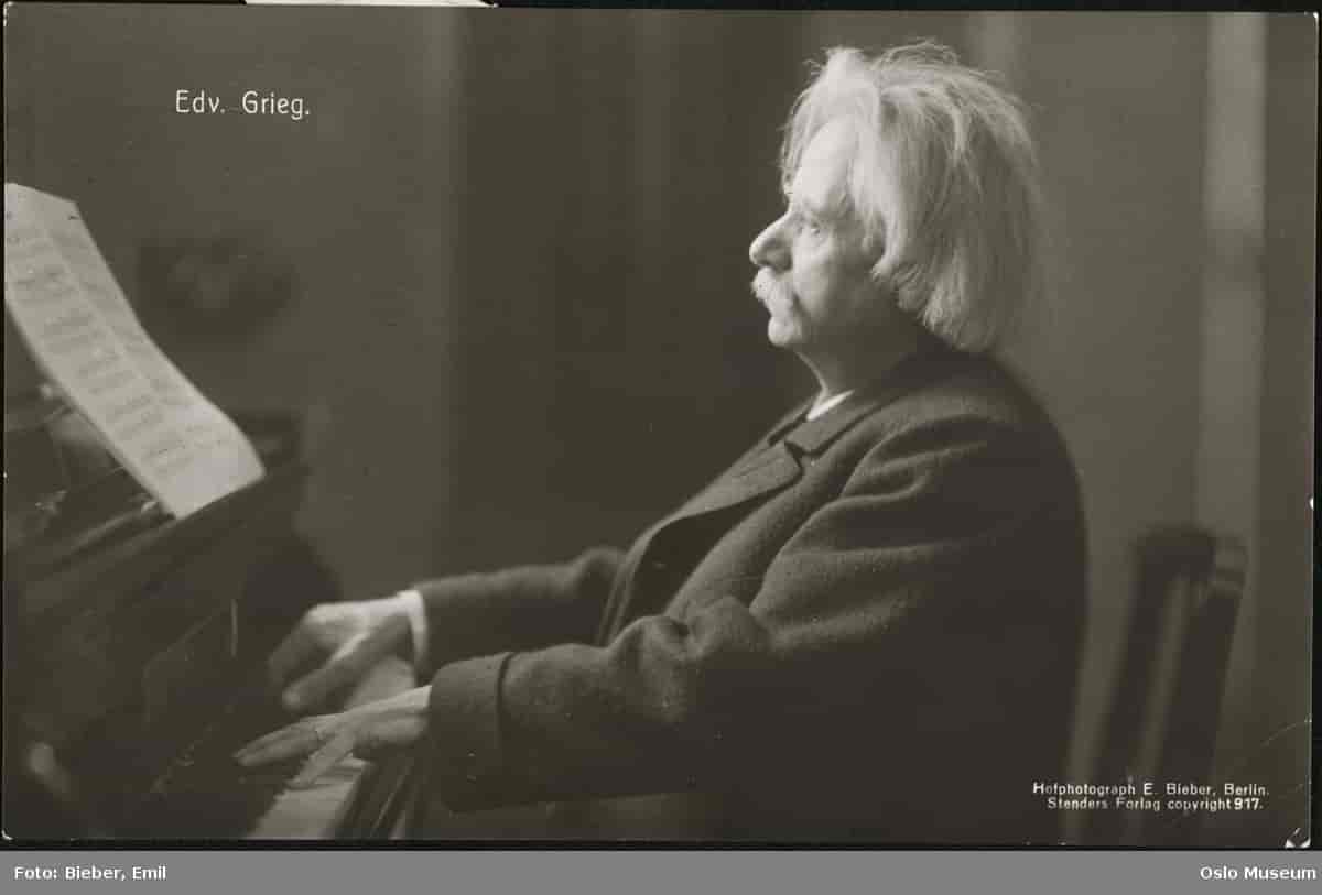 Foto av Grieg som spiller piano.