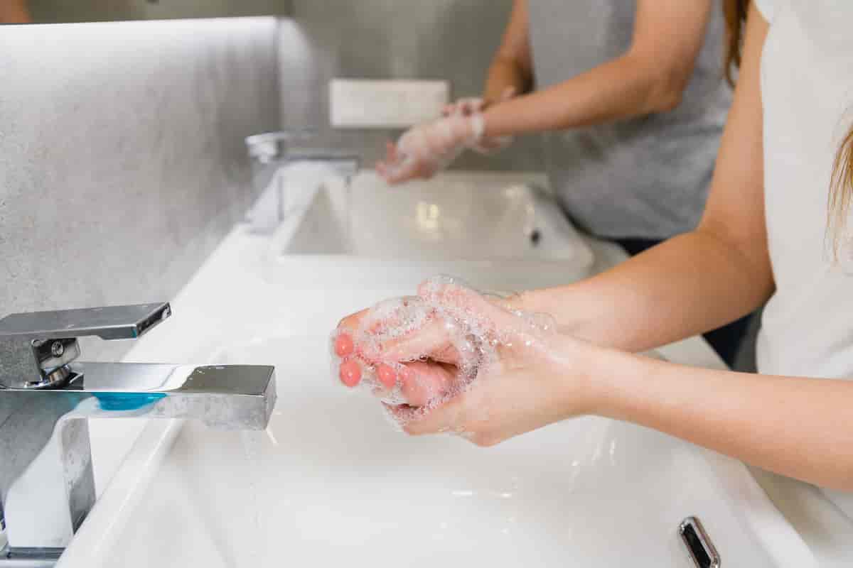 to kvinner som vasker hendene med såpe