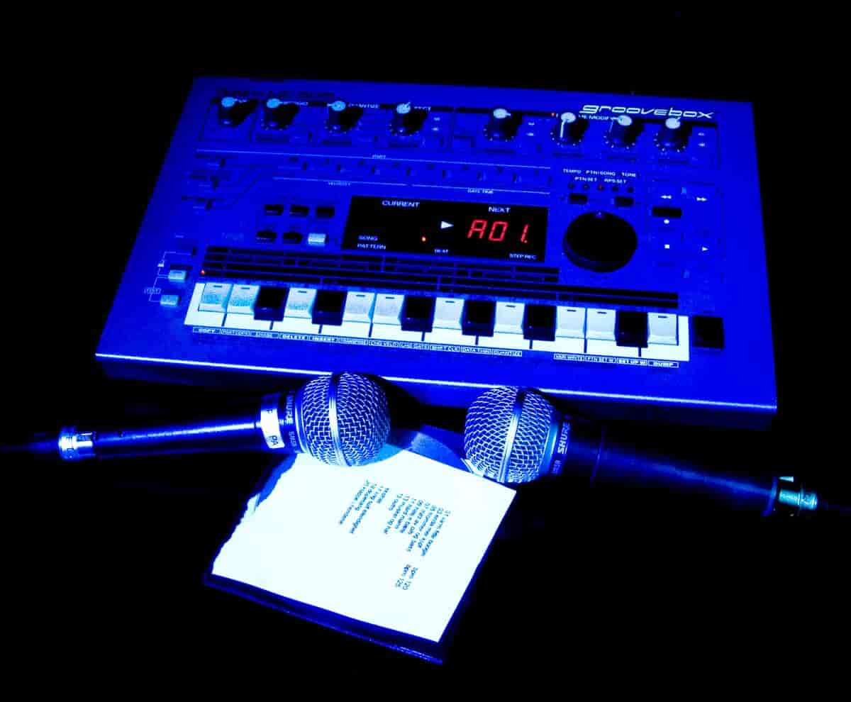 En blå boks med noen få pianotangenter, knapper og digitale tall. Foran ligger det to mikrofoner.