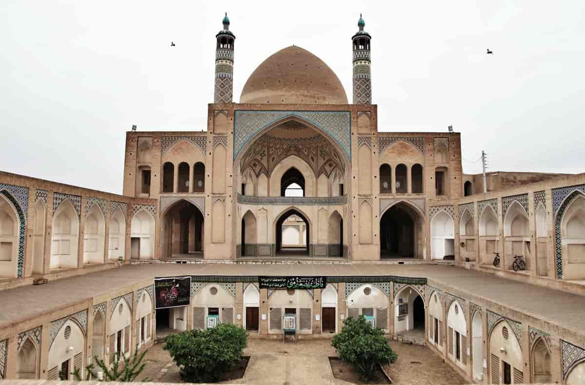 Fotografi som viser den åpne gårdsplassen inni en moské. Man ser kuppelen og de to tårnene til moskeen. 