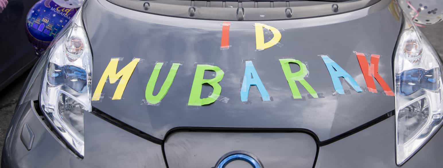 Fotografi av panseret på en bil der det står ID MUBARAK med store, fargerike papirbokstaver.