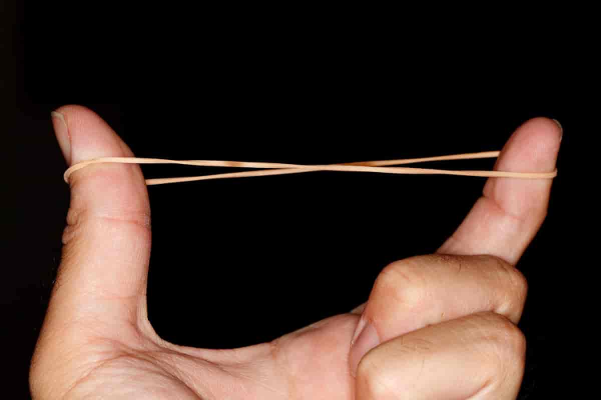 To fingre på en hånd som strekker en strikk mellom seg.