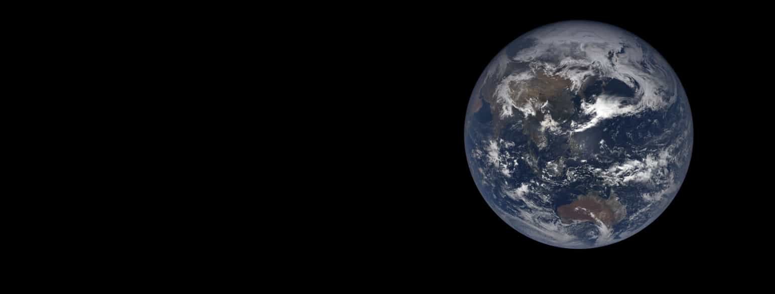 Satelittfoto av planeten Jorda mot en helt svart bakgrunn. Planeten er rund og har hav, kontinenter og skyer. Havet er blått, kontinentene er brune og grønne, og skyene er hvite.