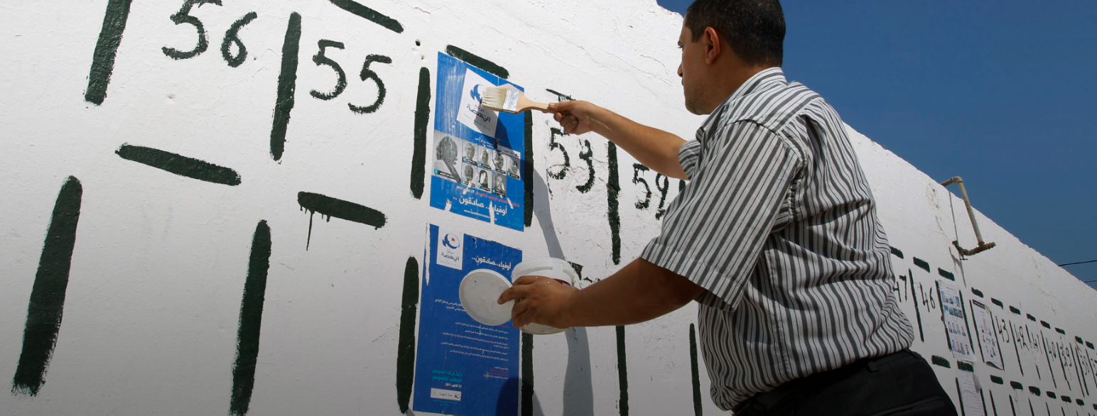 En tilhenger av islamistpartiet Al-Nahda henger opp valgplakater før valget i 2011