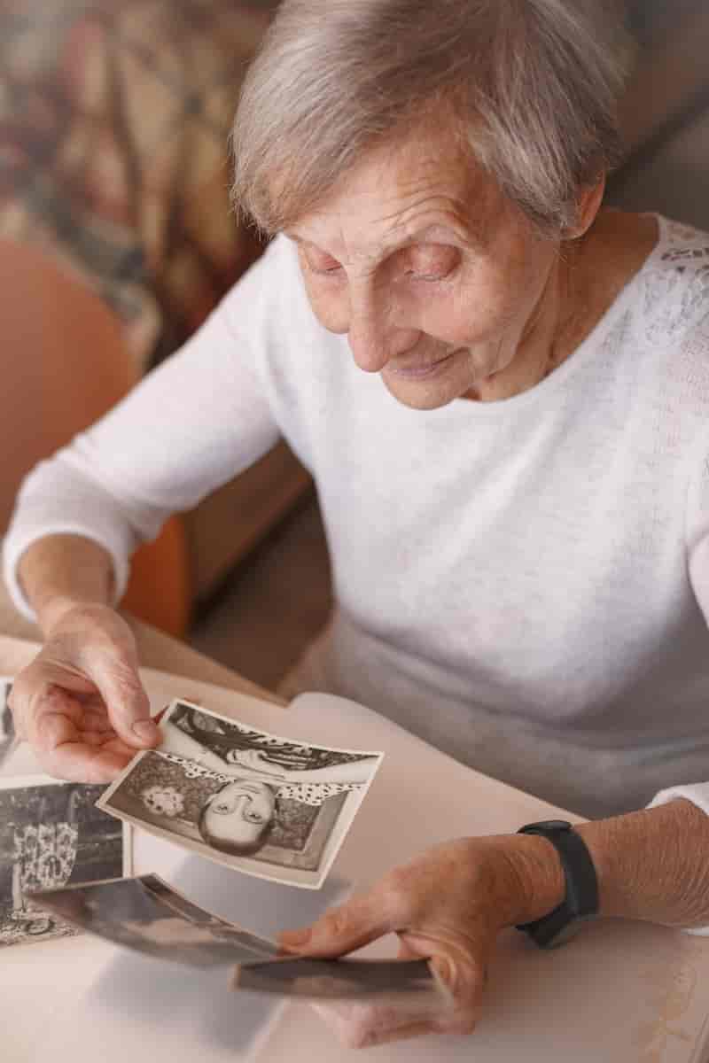 En eldre dame ser på et gammelt fotografi