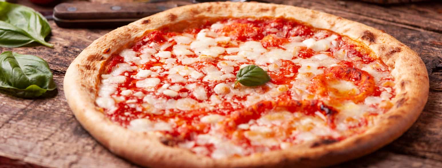 Foto av en pizza med tomatsaus og litt ost. 