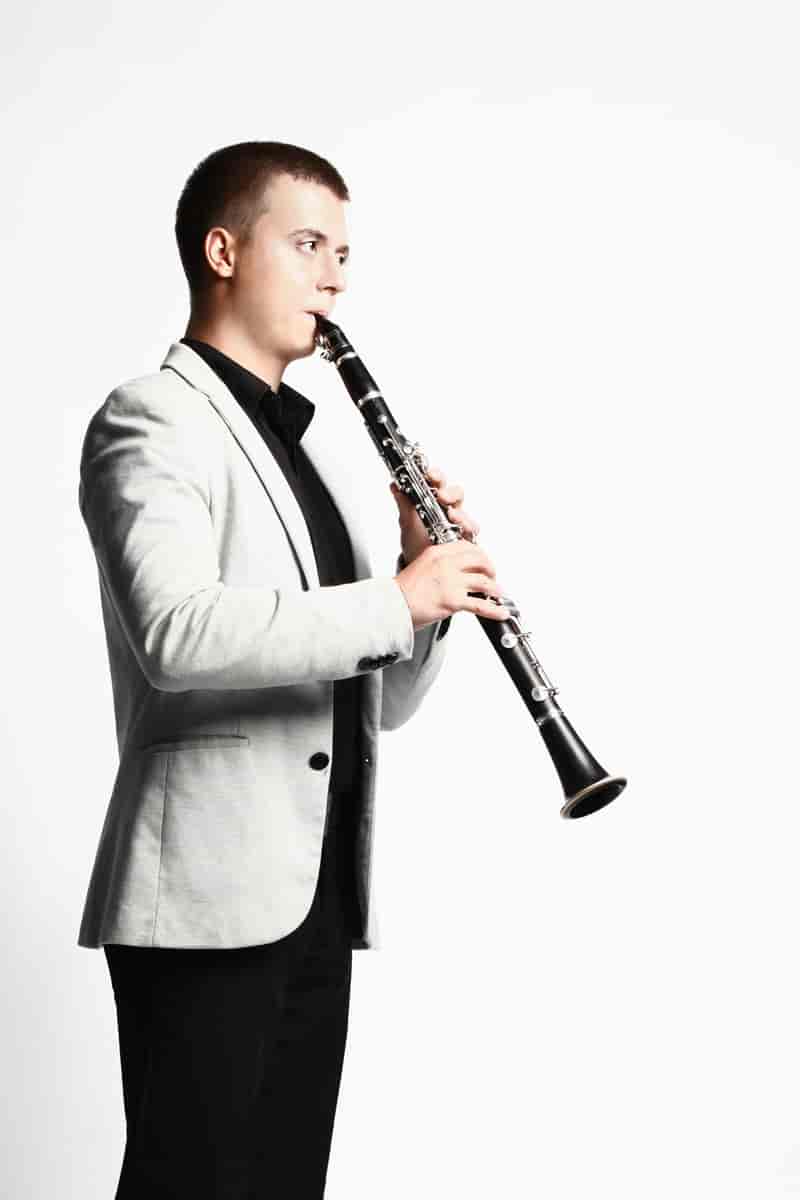 Mannlig klarinettist som blåser på en klarinett.