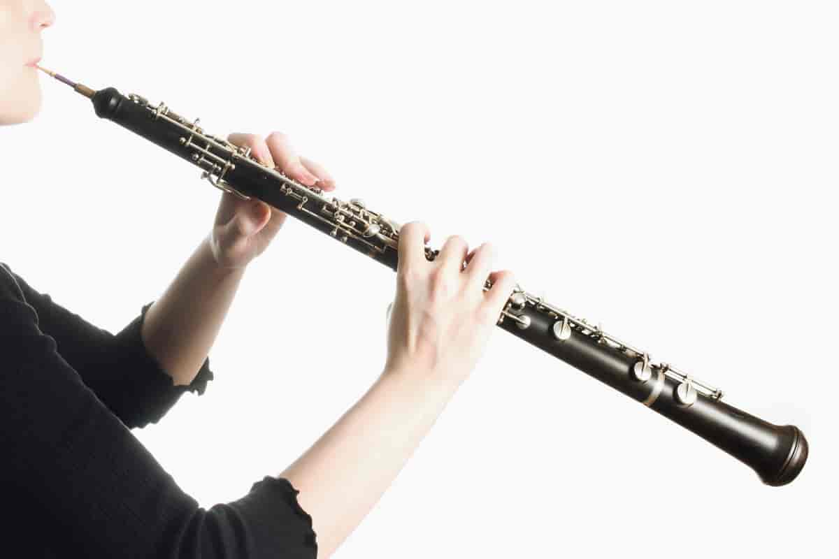 En ung mann i svart skjorte spiller på en obo.