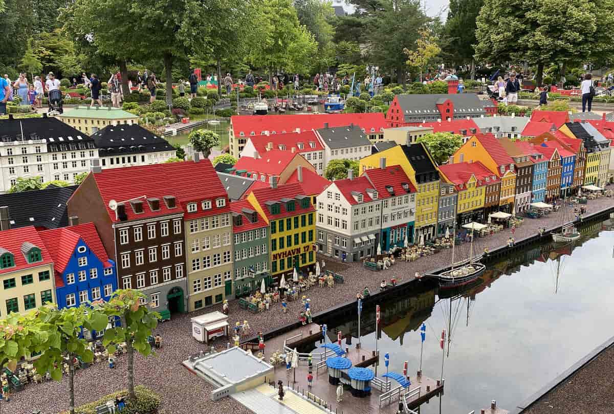 Bygninger i lego med en kanal foran og trær i bakgrunnen. Foto