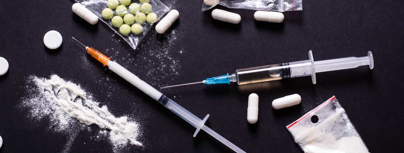 Fotografi av ulike former for narkotika: Sprøyter, pulver og tabletter. 