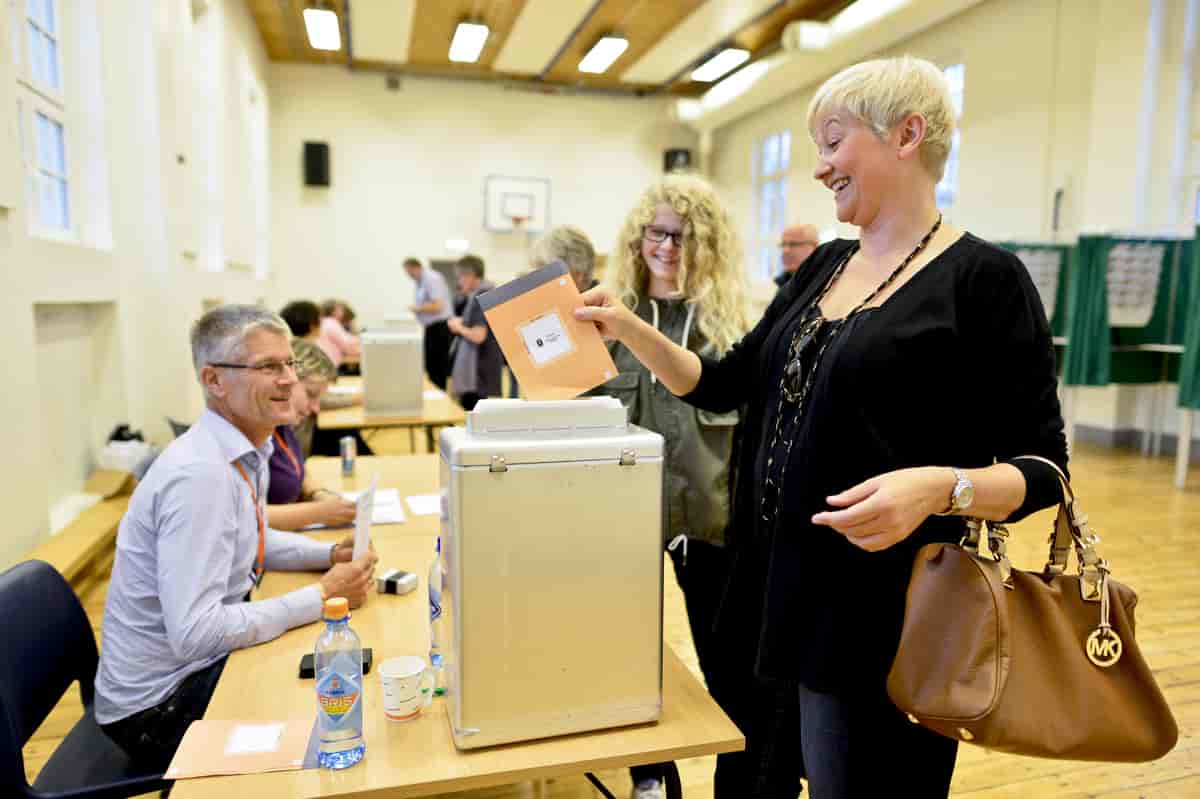 Kvinne legger stemmeseddel i valgurne
