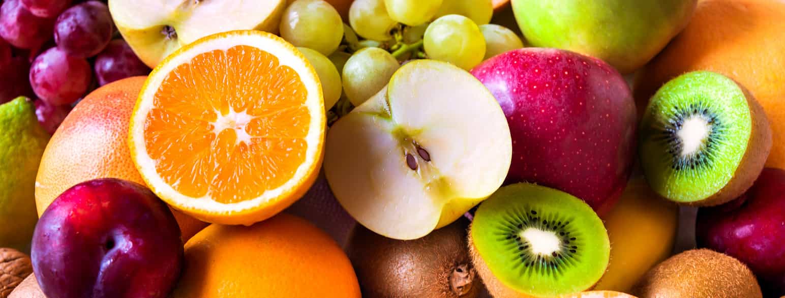 Forskjellig frukt. Appelsin, eple, kiwi, plomme og druer