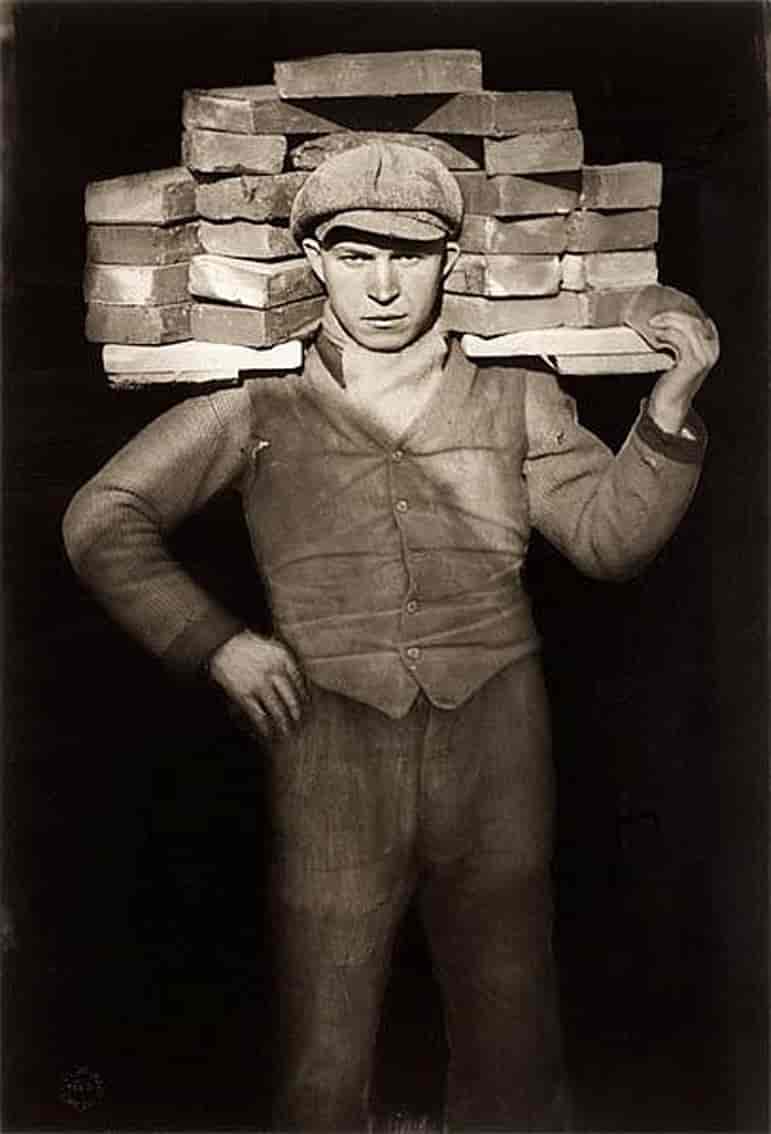 Ung mann som bærer murstein