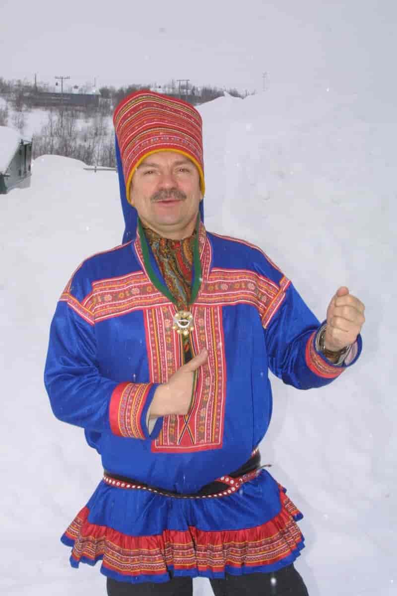 En mann i tradisjonell samisk drakt med lue for menn på hodet.