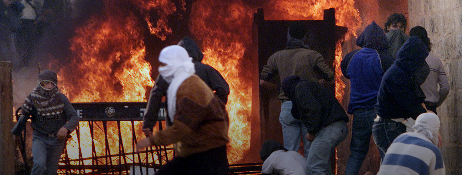 Palestinere ved en brennende barrikade i Jerusalem