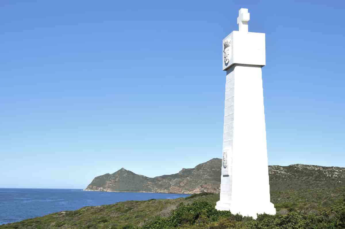 kvit høg skulptur på kanten av ein odde med utsyn over havet