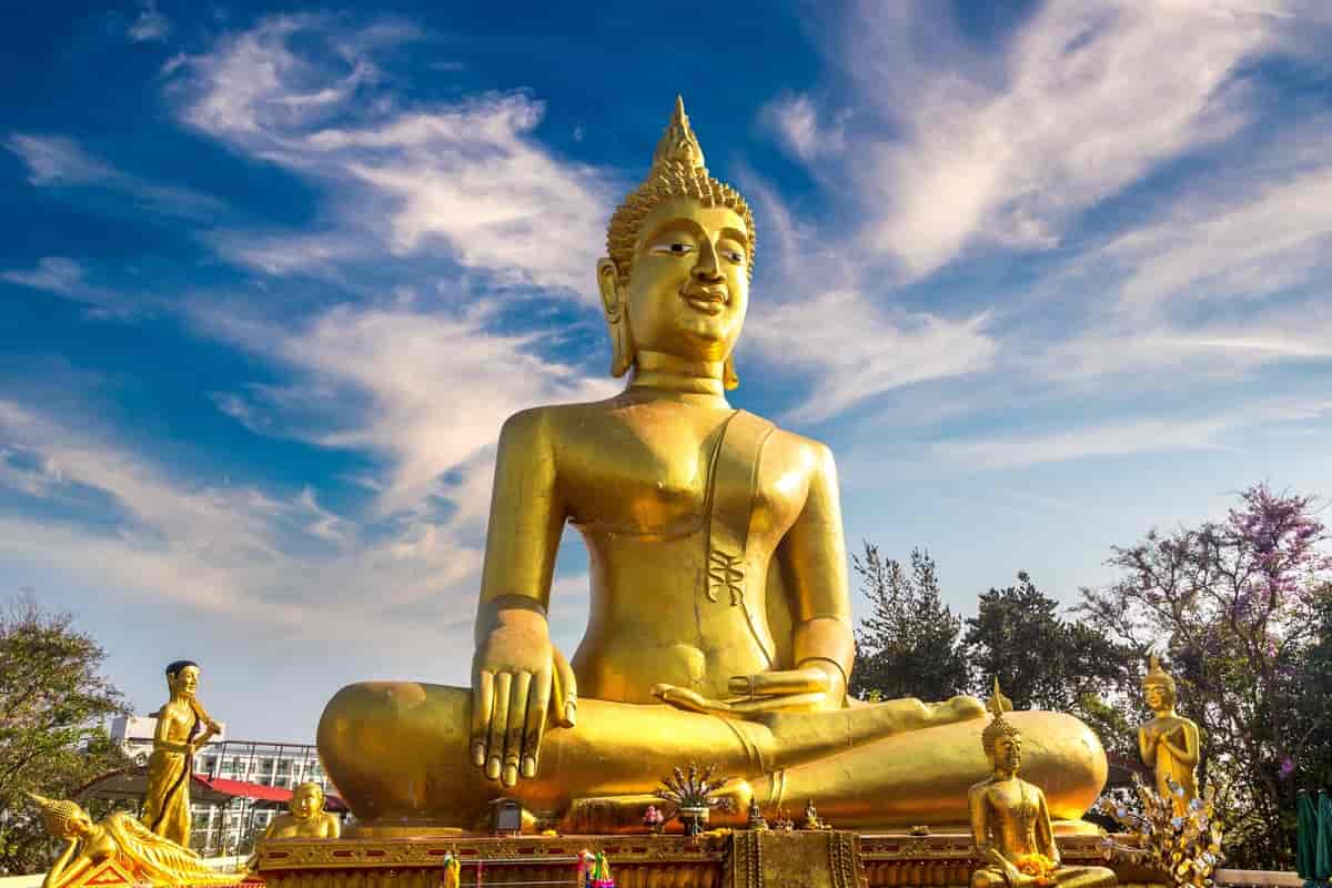 Bildet viser en stor gullstatue av Buddha som sitter med beina i kors.