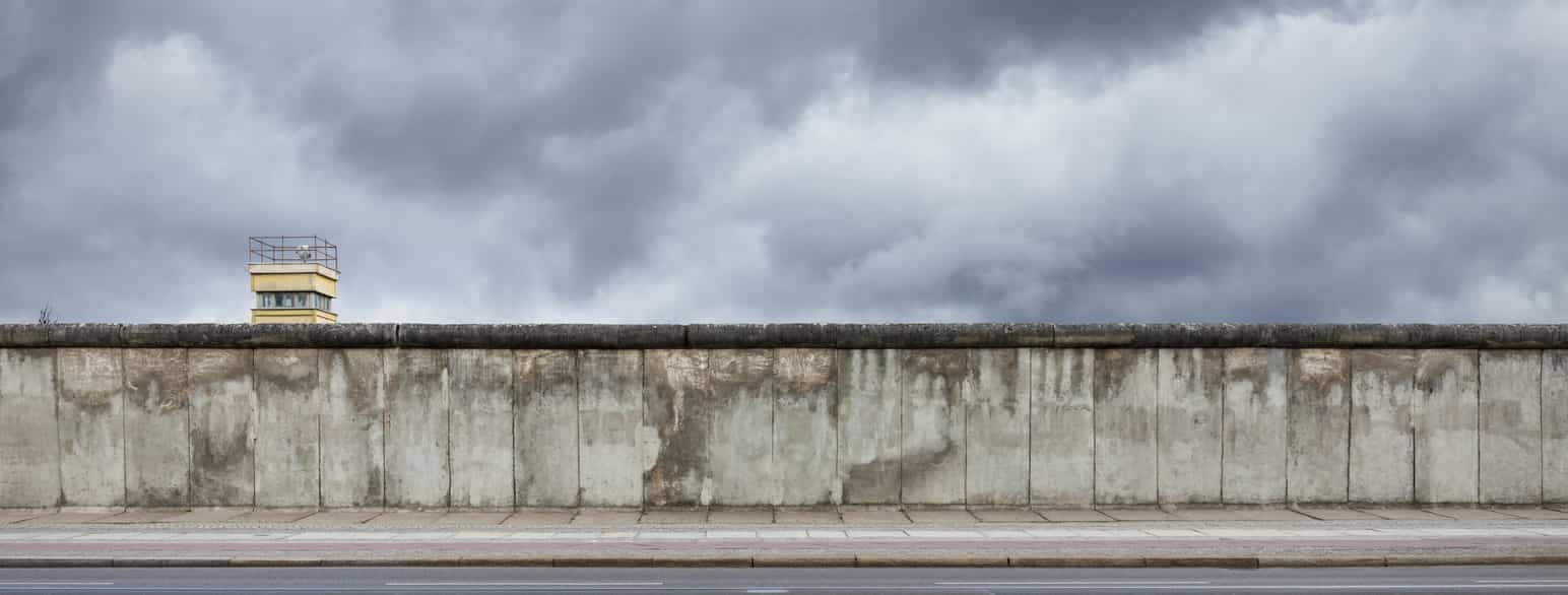 En mur i betong med et vakttårn på den ene siden. Foto