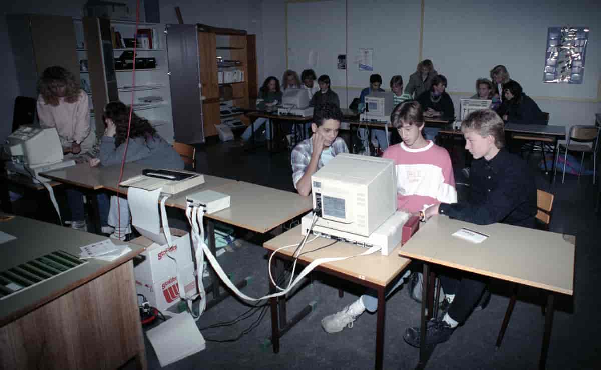 Tre gutter som sitter og ser inn i skjermen på en datamaskin.