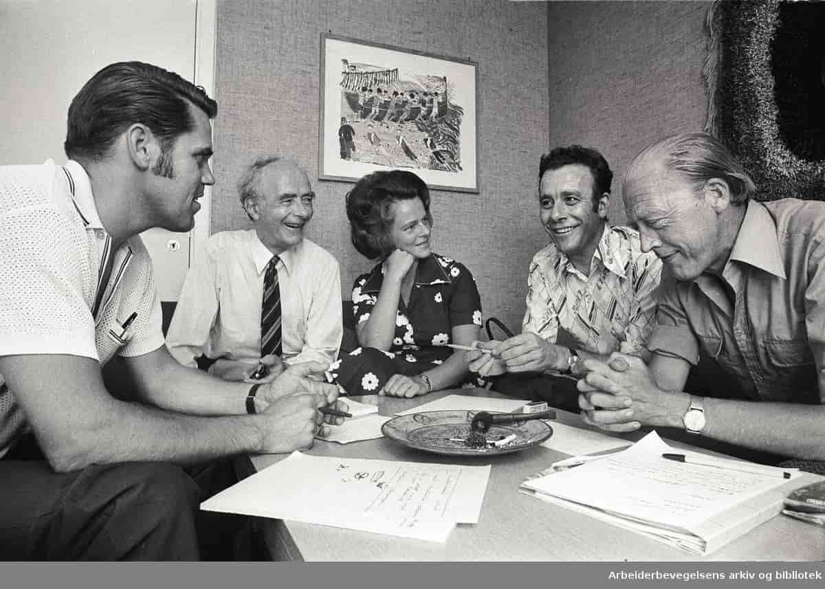Fotografi av Ivar Leveraas, Trygve Bratteli, Gro Harlem Brundtland, Reiulf Steen og Odvar Nordli i 1975. De fem politikerne sitter rundt et bord og smiler.