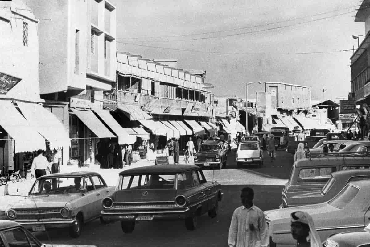 Sentrum av Doha fotografert i 1968 med biler og mennesker som går i gatene.