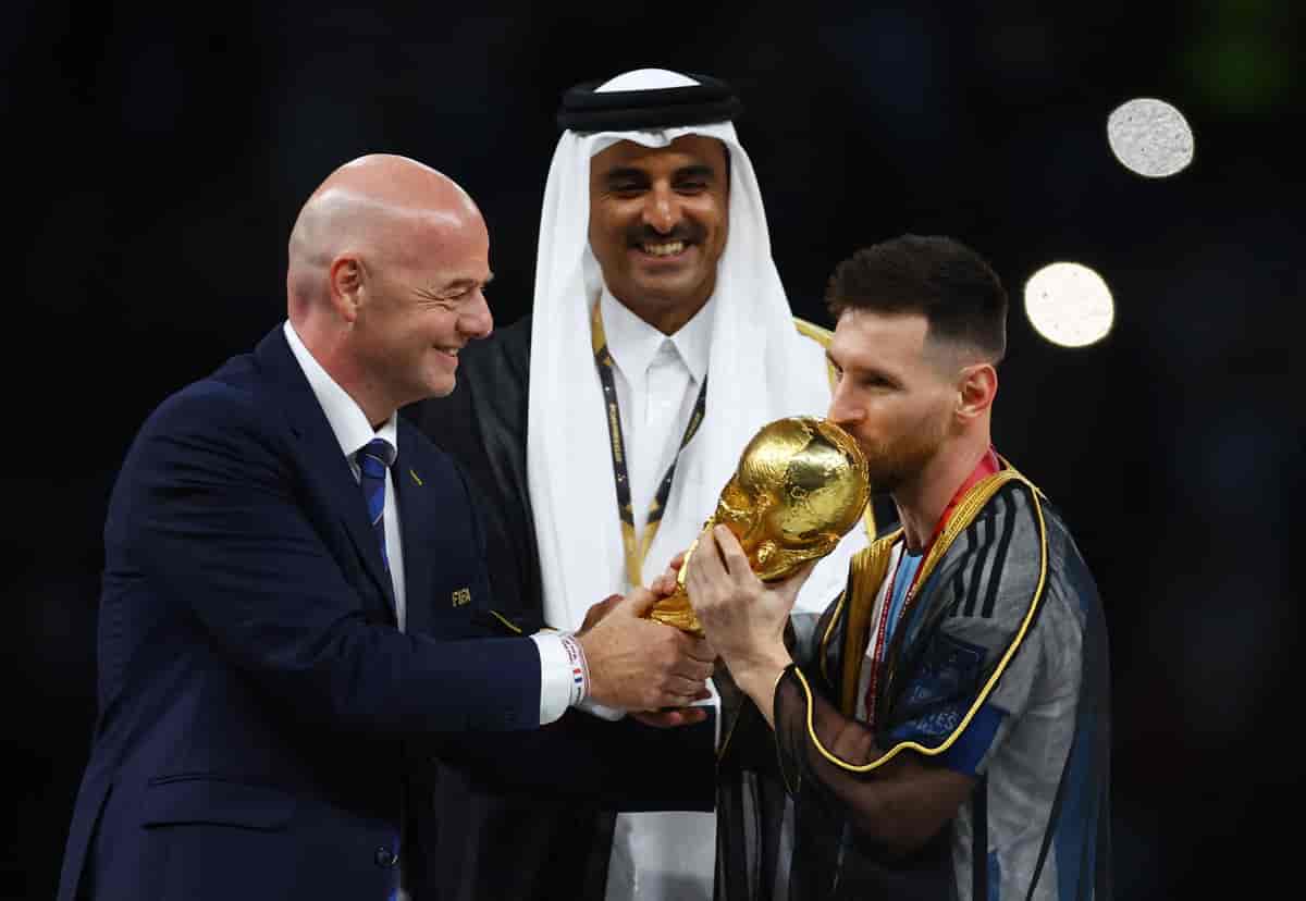 FIFA-president Gianni Infantino overrekker VM-trofeet til Lionel Messi med emiren Tamim bin Hamad Al Thani i bakgrunnen. 