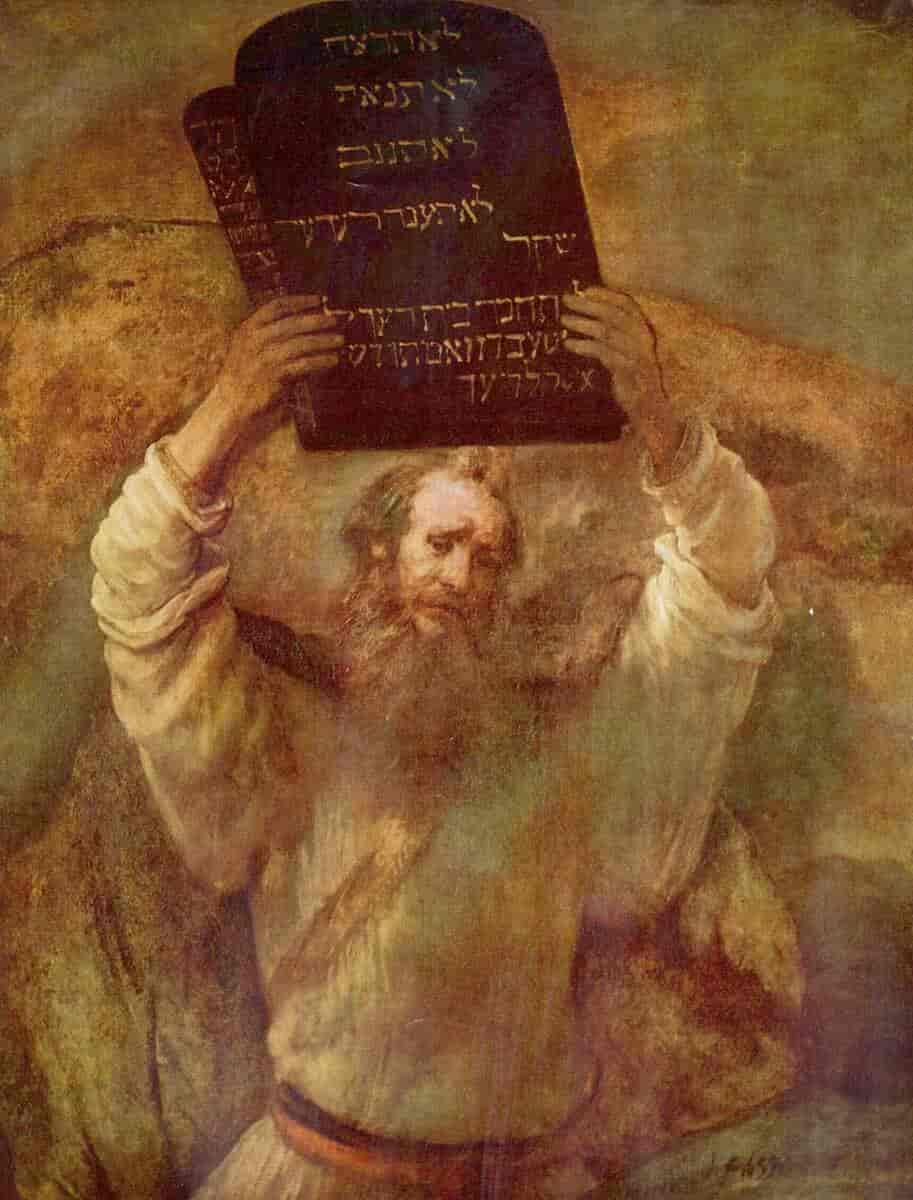Moses, framstilt som en gammel mann med skjegg holder to steintavler med skrift i gull over hodet.