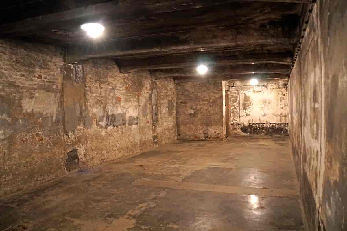 Fotografiet viser et stort, tomt rom med murvegger og betonggulv.