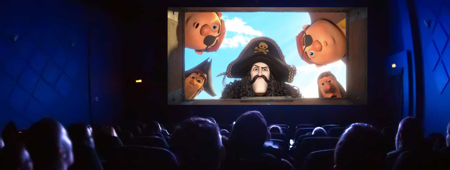 To bilder redigert sammen. Det ene er fra animasjonsfilmen «Kaptein Sabeltann og Den Magiske Diamant» det andre er av mennesker som sitter i en mørk kinosal. Stillbildet er klippet inn på kinolerretet.